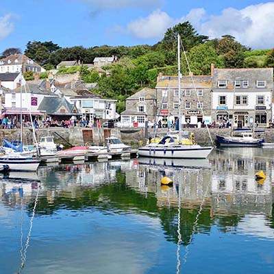 Padstow's working harbour with moored fishing boats and harbourside restaurants, North Cornwall
