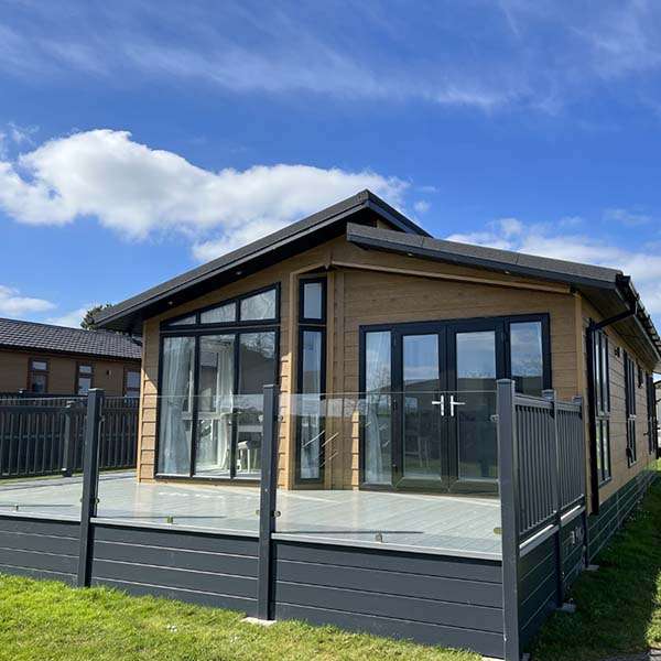 Luxury lodge exterior with raised timber decking and steps at Atlantic Bays, Padstow
