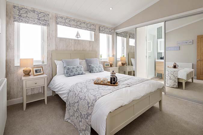 Comfortable lodge bedroom with made-up bed at Atlantic Bays Holiday Park